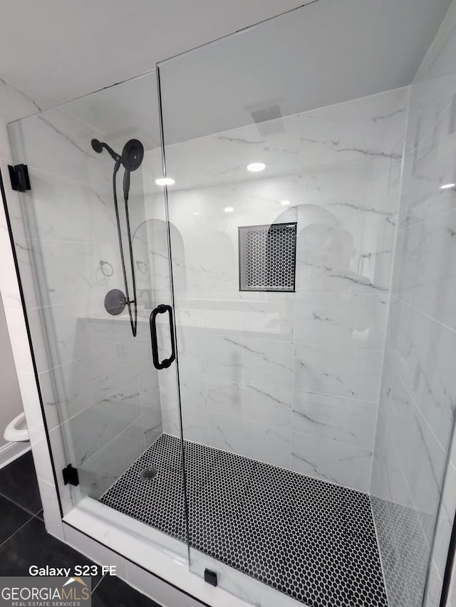 bathroom with tile patterned flooring and a stall shower