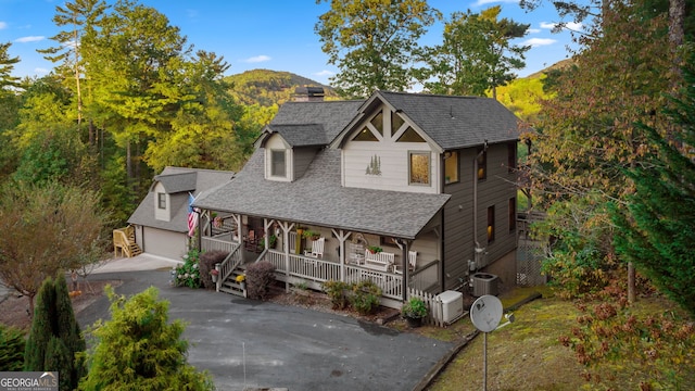 709 Laurel Creek Trl, Blue Ridge, GA 30513 - view of front of home with an outdoor structure, cooling unit, a shingled roof, a porch, and a mountain view
