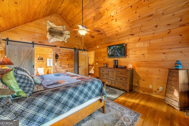 709 Laurel Creek Trl, Blue Ridge, GA 30513 - bedroom featuring vaulted ceiling, a barn door, wooden ceiling, wood-type flooring, and wooden walls