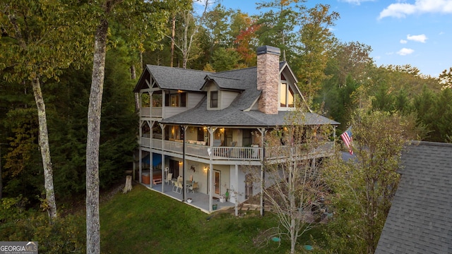 709 Laurel Creek Trl, Blue Ridge, GA 30513 - back of property featuring roof with shingles, a chimney, a patio area, a balcony, and a yard