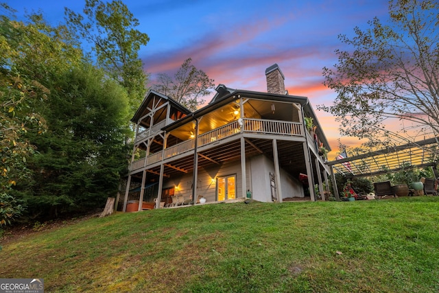 709 Laurel Creek Trl, Blue Ridge, GA 30513 - back of house at dusk featuring a wooden deck, a chimney, and a yard