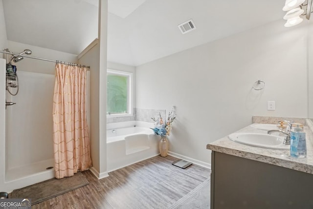 11028 Southwood Dr, Hampton, GA 30228 - full bathroom featuring visible vents, lofted ceiling, wood finished floors, a bath, and a shower stall