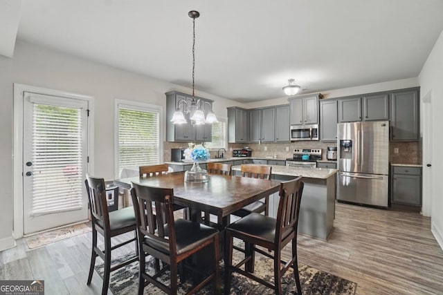 11028 Southwood Dr, Hampton, GA 30228 - dining space with an inviting chandelier, baseboards, and light wood-style flooring