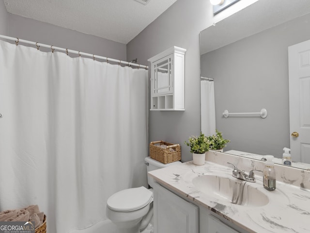bathroom featuring toilet, a textured ceiling, and vanity