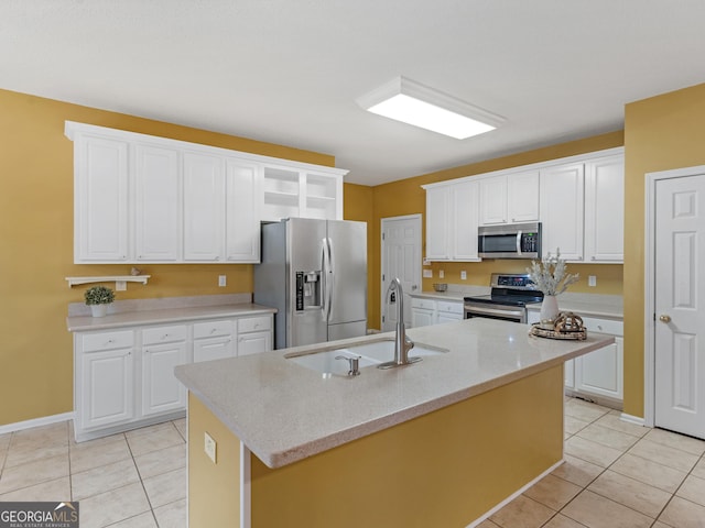 kitchen featuring appliances with stainless steel finishes, open shelves, a sink, light tile patterned floors, and white cabinetry