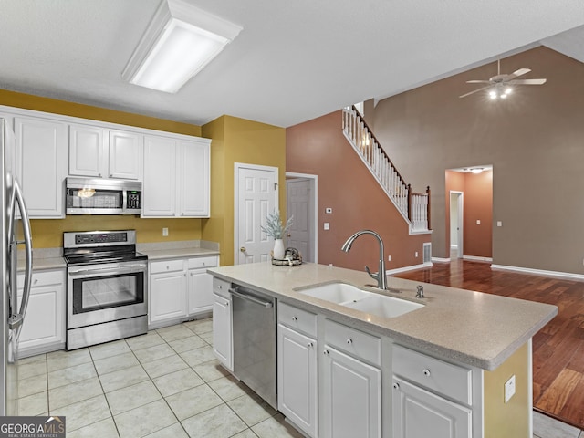 kitchen featuring ceiling fan, light countertops, white cabinets, a sink, and appliances with stainless steel finishes