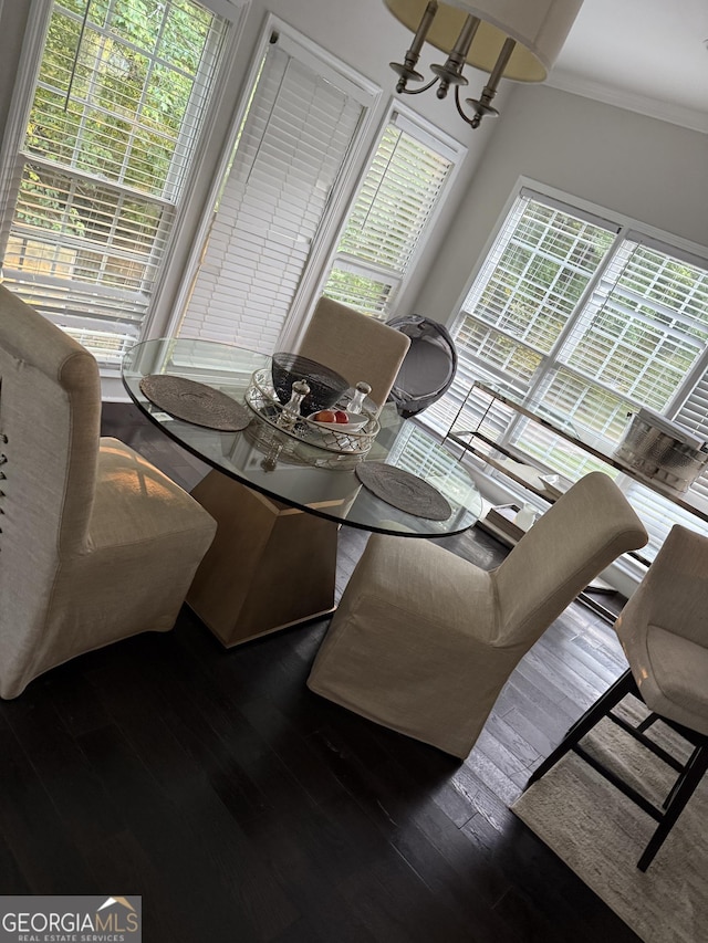 dining area featuring wood finished floors, a chandelier, and crown molding