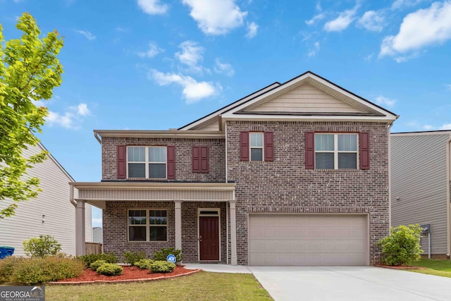 view of front of home with an attached garage, driveway, a front lawn, and brick siding