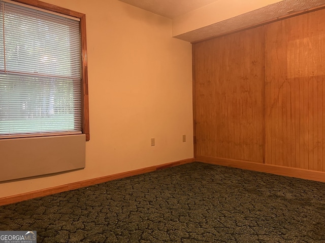 carpeted spare room featuring baseboards