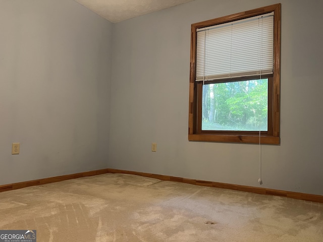 carpeted spare room with baseboards