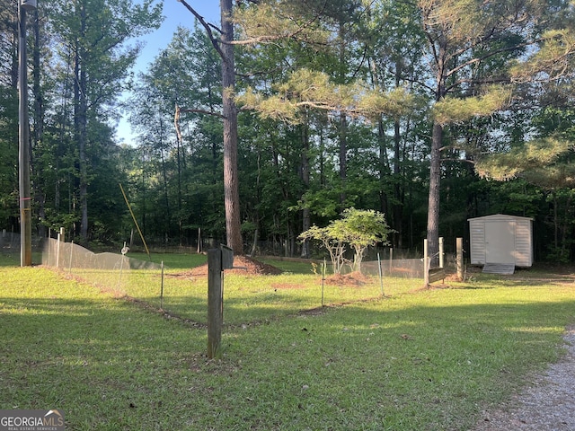view of yard with fence, an outdoor structure, and a storage unit