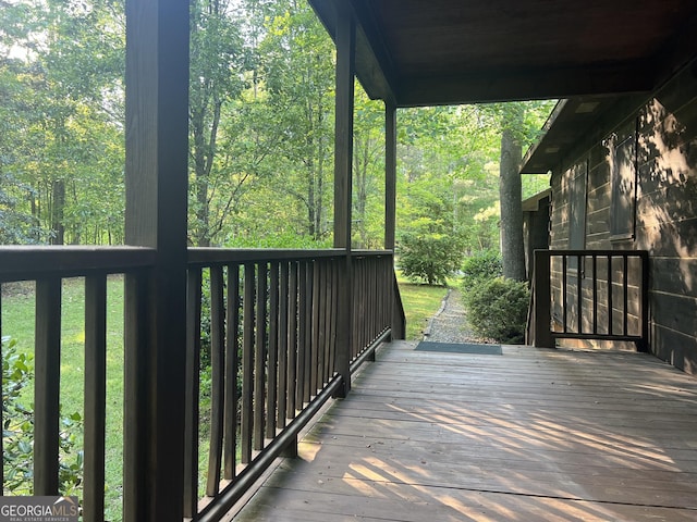 wooden terrace featuring a view of trees