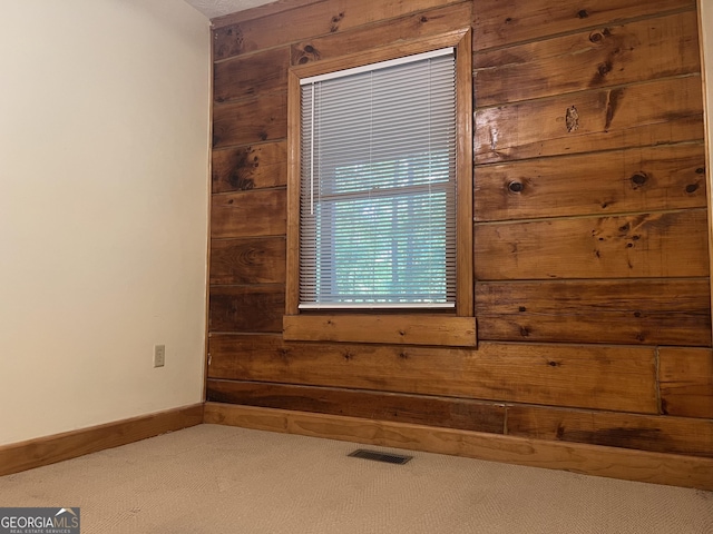 details with wooden walls, baseboards, carpet, and visible vents