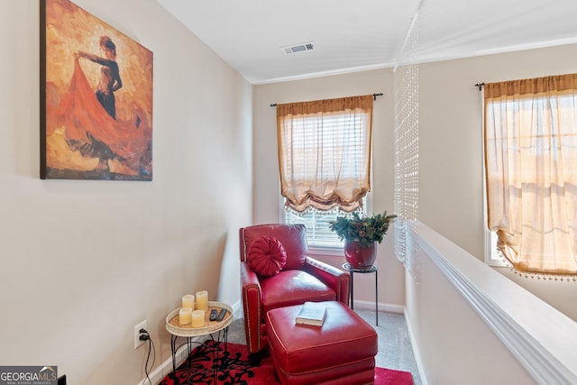 living area with visible vents, carpet, baseboards, and plenty of natural light