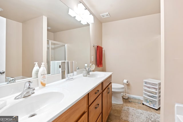 bathroom with a sink, a shower stall, double vanity, and visible vents