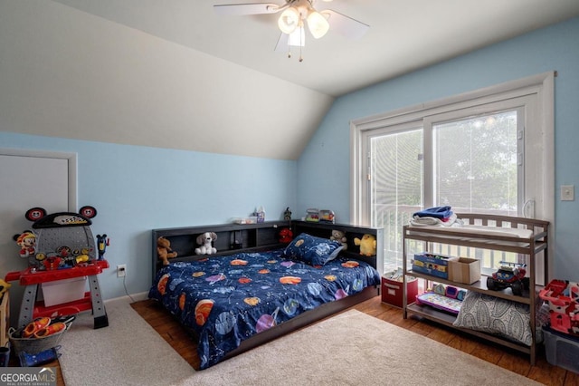 bedroom with ceiling fan, wood finished floors, and lofted ceiling