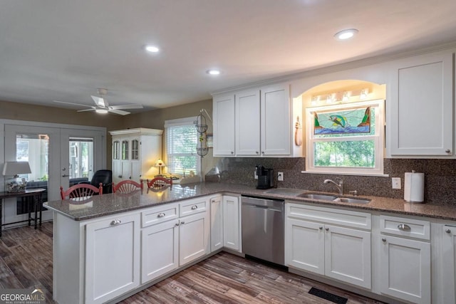 kitchen with a peninsula, white cabinetry, french doors, a sink, and dishwasher