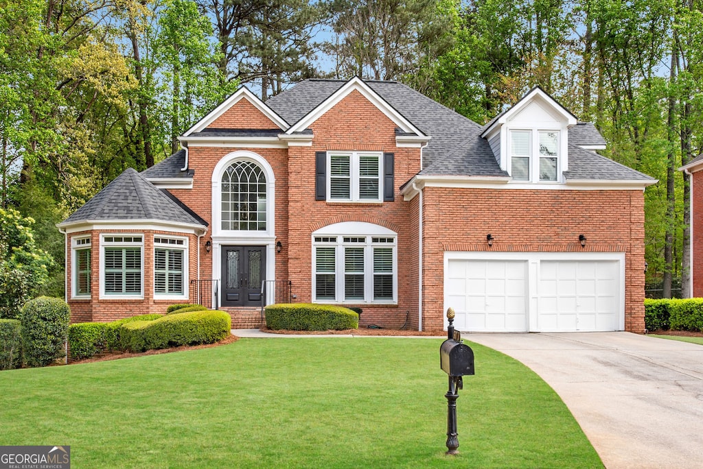 6070 Poplar Spring Dr, Peachtree Corners, GA 30092 - view of front of house featuring a shingled roof, a front lawn, brick siding, concrete driveway, and french doors