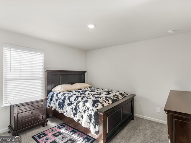 bedroom with baseboards and light carpet
