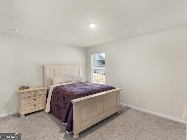 bedroom with baseboards and light carpet