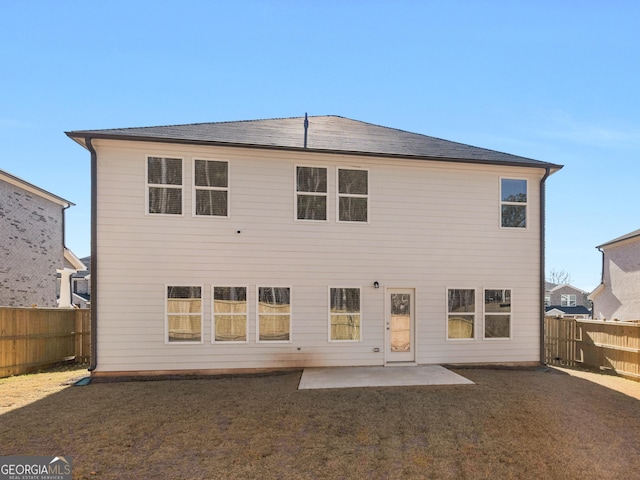 rear view of property with a fenced backyard, a lawn, and a patio area