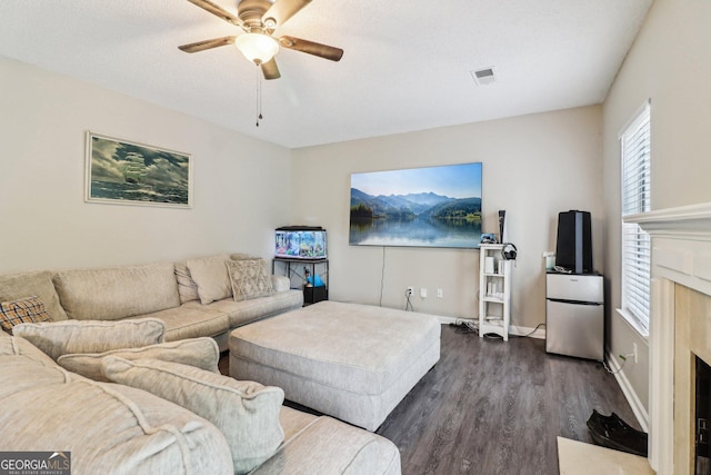 4015 Soaring Dr, Douglasville, GA 30135 - living room featuring ceiling fan, visible vents, a fireplace, baseboards, and dark wood-style floors