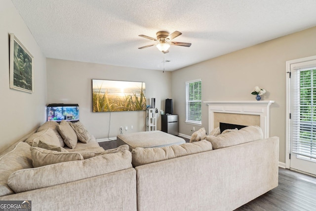 4015 Soaring Dr, Douglasville, GA 30135 - living area with dark wood-style flooring, ceiling fan, baseboards, and a fireplace