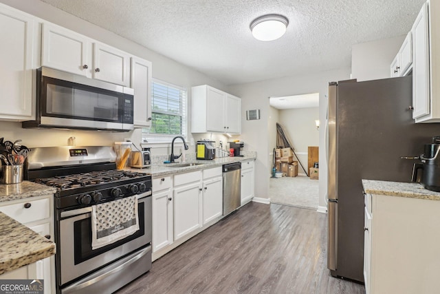 4015 Soaring Dr, Douglasville, GA 30135 - kitchen featuring a sink, appliances with stainless steel finishes, a textured ceiling, and white cabinetry