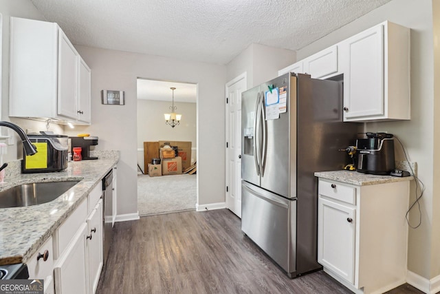 4015 Soaring Dr, Douglasville, GA 30135 - kitchen with white cabinets, dark wood-style flooring, appliances with stainless steel finishes, a sink, and a chandelier