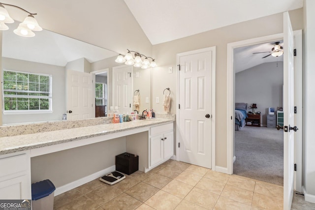 4015 Soaring Dr, Douglasville, GA 30135 - bathroom featuring tile patterned flooring, vanity, lofted ceiling, baseboards, and connected bathroom