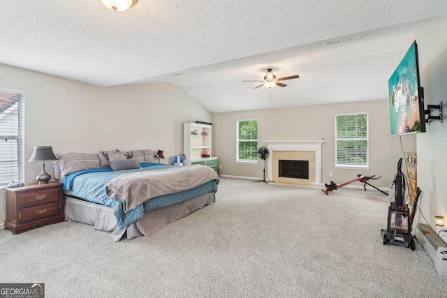 4015 Soaring Dr, Douglasville, GA 30135 - carpeted bedroom featuring a ceiling fan, lofted ceiling, baseboards, a textured ceiling, and a fireplace with flush hearth