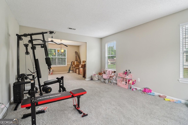 4015 Soaring Dr, Douglasville, GA 30135 - workout area with a notable chandelier, carpet flooring, a textured ceiling, and visible vents