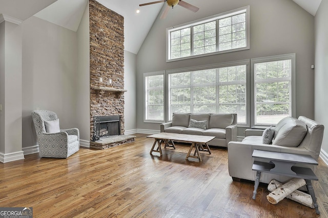 living area with high vaulted ceiling, a healthy amount of sunlight, ceiling fan, and wood finished floors