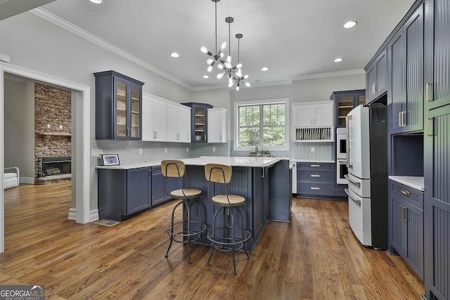kitchen featuring light countertops, freestanding refrigerator, recessed lighting, backsplash, and glass insert cabinets