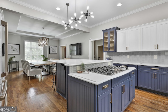 kitchen featuring blue cabinetry, stainless steel gas cooktop, light countertops, a chandelier, and dark wood-type flooring