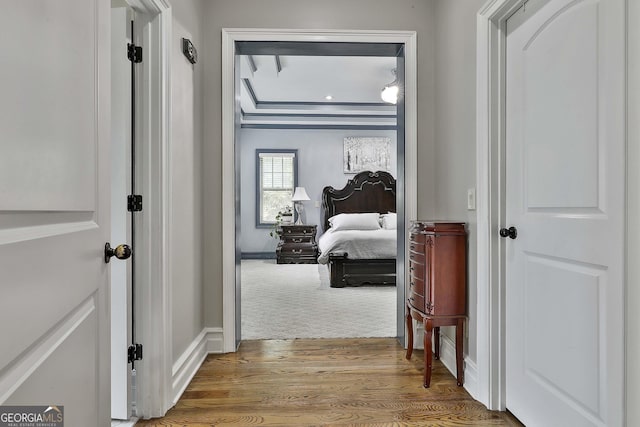 corridor with baseboards and wood finished floors