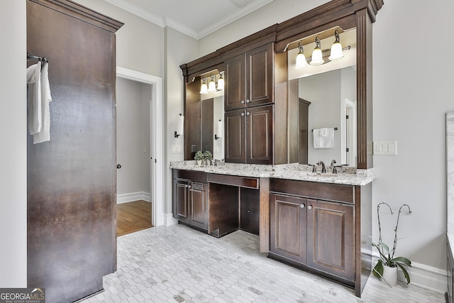 full bathroom featuring a sink, baseboards, crown molding, and double vanity