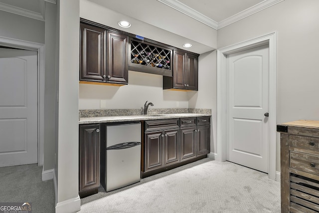 bar with ornamental molding, refrigerator, light carpet, indoor wet bar, and a sink
