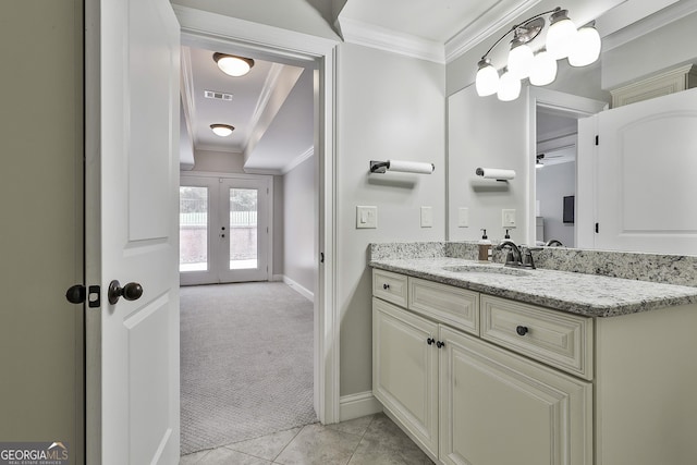 bathroom featuring vanity, french doors, baseboards, visible vents, and ornamental molding