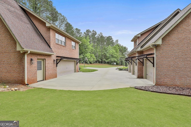 view of yard with an attached garage and driveway