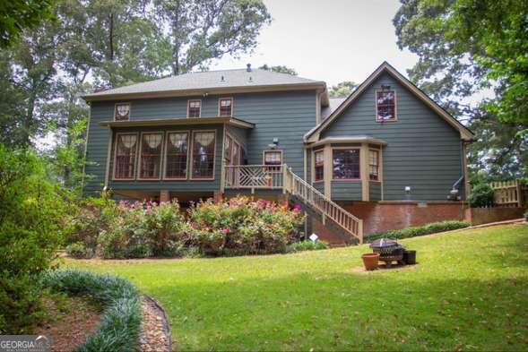 2646 Kinnett Dr SW, Lilburn, GA 30047 - rear view of property featuring a lawn, an outdoor fire pit, a deck, and stairway