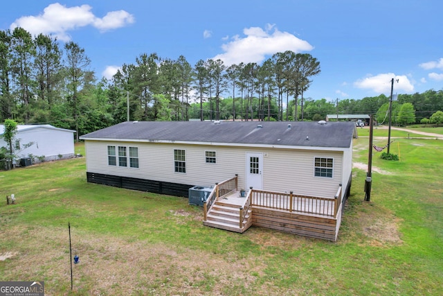 back of property featuring a yard, central AC, and a wooden deck