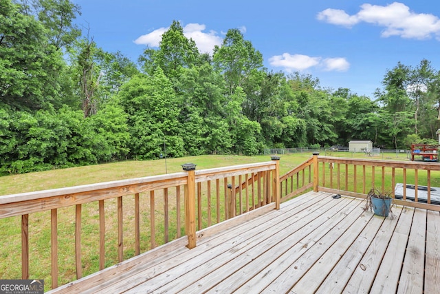 deck featuring a fenced backyard, an outbuilding, a shed, and a yard