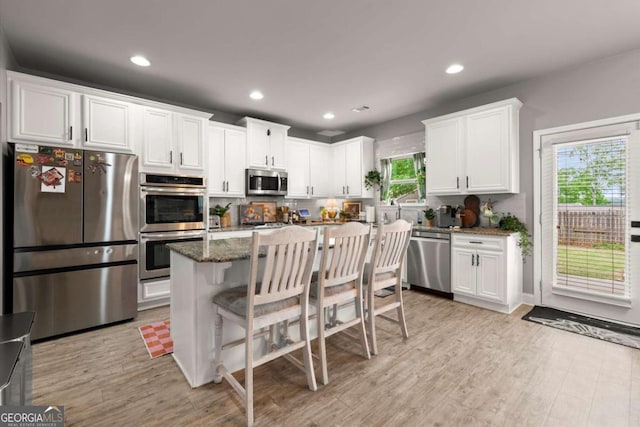 188 Lookout Way, Dallas, GA 30132 - kitchen featuring a center island, white cabinets, dark stone counters, stainless steel appliances, and light wood-style flooring
