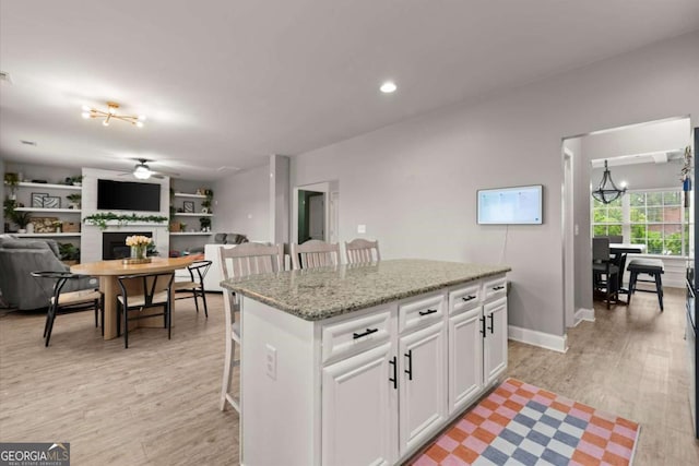 188 Lookout Way, Dallas, GA 30132 - kitchen featuring ceiling fan, a breakfast bar area, a center island, open floor plan, and white cabinetry
