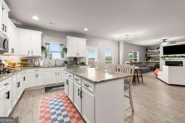 188 Lookout Way, Dallas, GA 30132 - kitchen with a breakfast bar, a sink, stainless steel microwave, a kitchen island, and visible vents