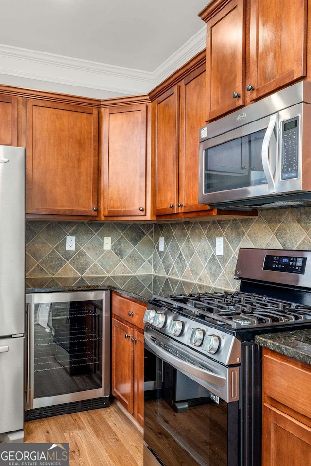 kitchen with light wood-style flooring, stainless steel appliances, brown cabinets, and beverage cooler