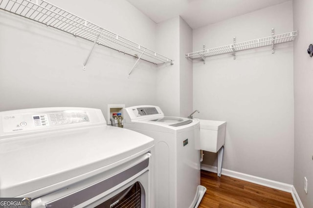 washroom with laundry area, baseboards, wood finished floors, and washer and dryer