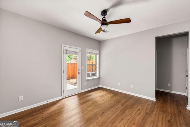 unfurnished room featuring baseboards, a ceiling fan, wood finished floors, and visible vents