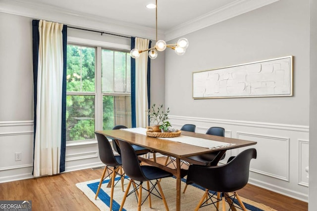 dining space featuring wainscoting, ornamental molding, a wealth of natural light, and wood finished floors